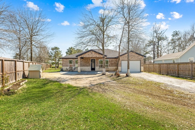 back of property featuring a patio, brick siding, fence, driveway, and a lawn