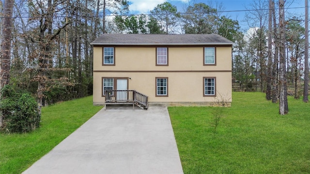 back of property featuring a yard and stucco siding