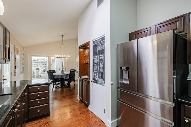 kitchen featuring stainless steel fridge with ice dispenser, lofted ceiling, wood finished floors, hanging light fixtures, and dark brown cabinets