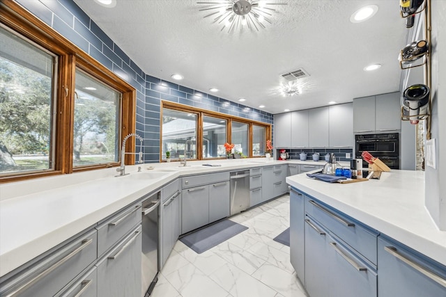 kitchen with gray cabinets, marble finish floor, light countertops, and a textured ceiling