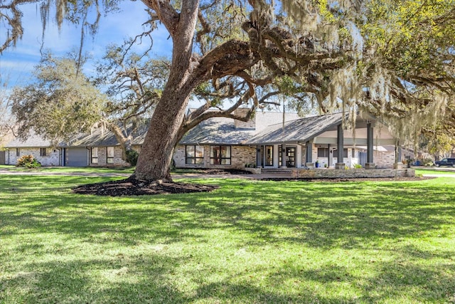 view of front facade with brick siding and a front lawn