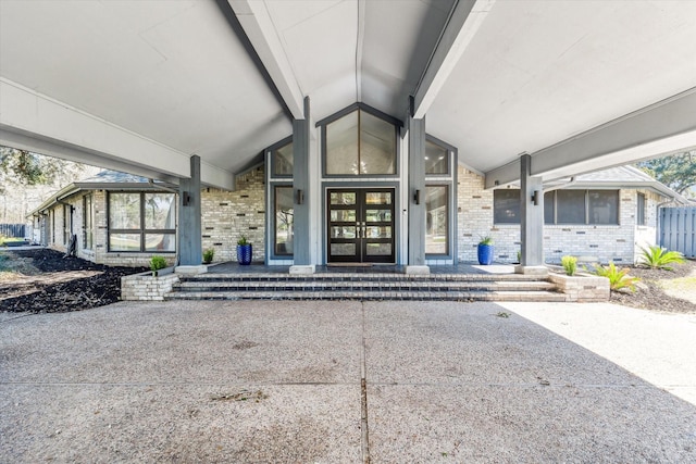 entrance to property featuring a patio area, french doors, and brick siding