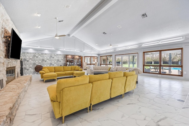 living room with visible vents, marble finish floor, a stone fireplace, and a ceiling fan