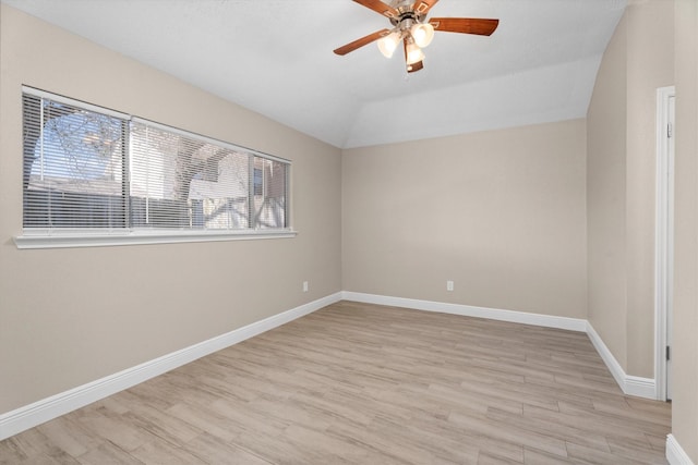 unfurnished room with light wood-style flooring, baseboards, and vaulted ceiling