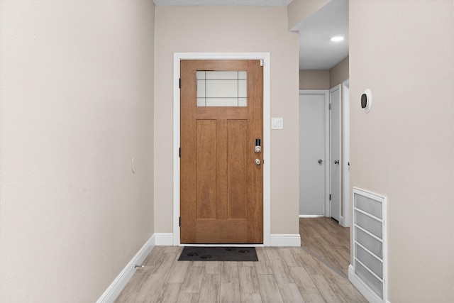 entrance foyer with baseboards and light wood-style floors