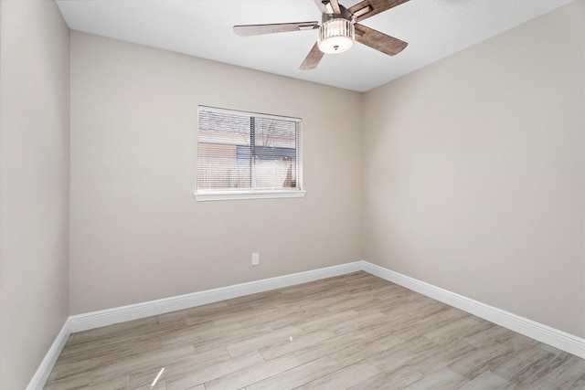 spare room featuring light wood finished floors and baseboards