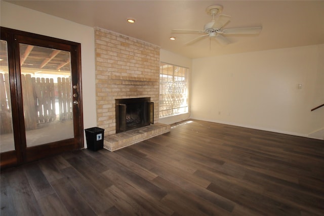 unfurnished living room featuring ceiling fan, a brick fireplace, dark wood finished floors, and recessed lighting