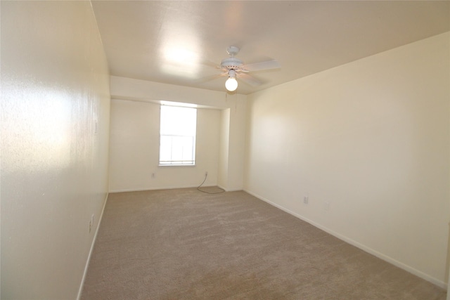 empty room featuring carpet floors, ceiling fan, and baseboards