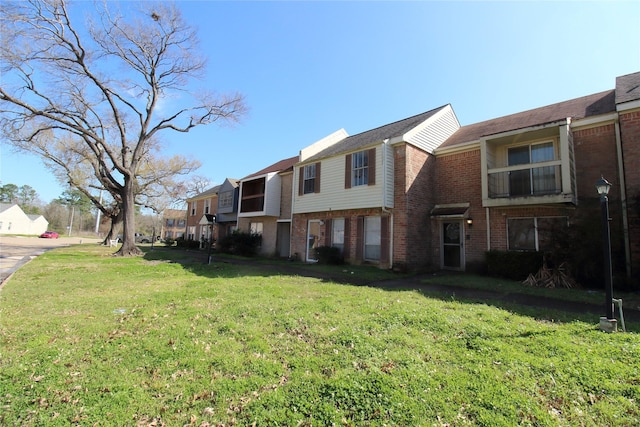 view of front of house with a front yard and brick siding