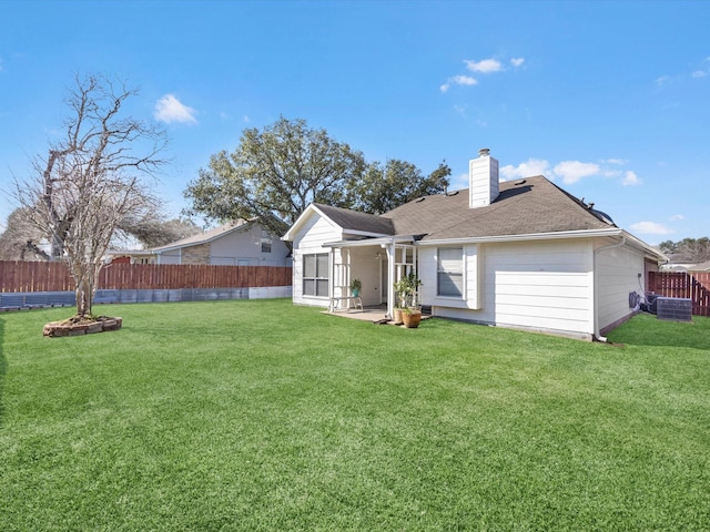 rear view of property featuring a patio area, a lawn, a chimney, and a fenced backyard