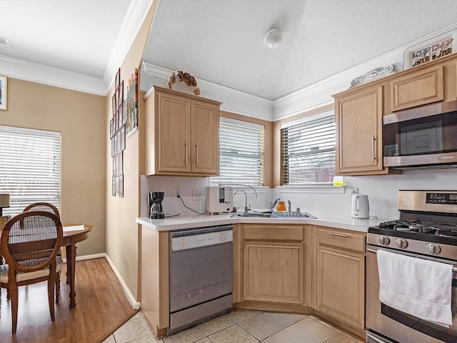 kitchen featuring stainless steel appliances, a sink, visible vents, light countertops, and ornamental molding