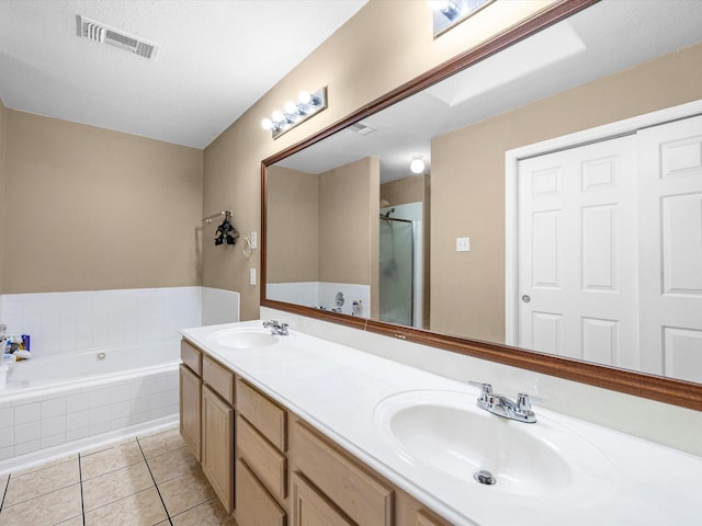 bathroom featuring a bath, tile patterned flooring, visible vents, and a sink