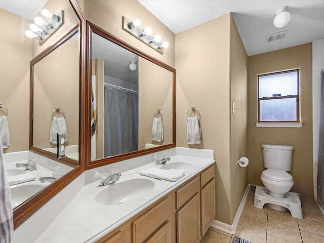 bathroom with double vanity, tile patterned flooring, visible vents, and a sink