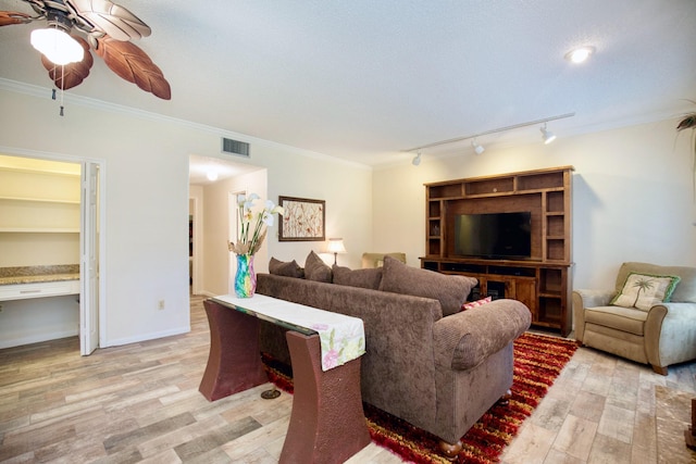 living room with visible vents, baseboards, a ceiling fan, light wood finished floors, and crown molding