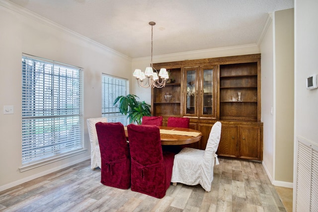 dining room featuring light wood-type flooring, visible vents, ornamental molding, and a notable chandelier