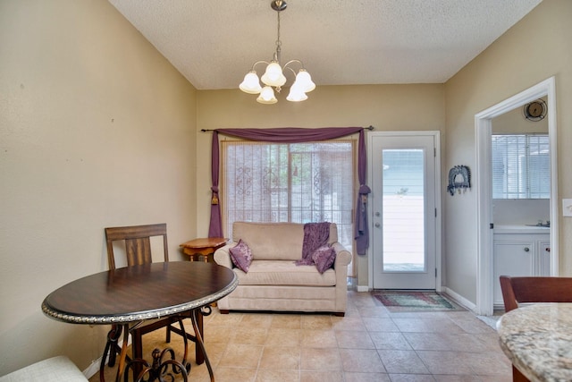 dining space featuring a textured ceiling, baseboards, light tile patterned flooring, and a notable chandelier