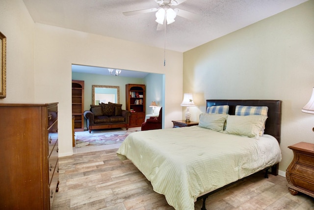 bedroom with light wood-style flooring, ceiling fan, a textured ceiling, and baseboards