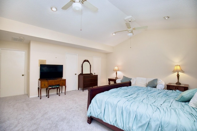 bedroom featuring ceiling fan, a textured ceiling, light carpet, visible vents, and vaulted ceiling