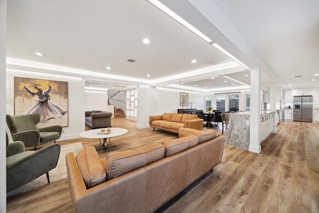 living room with light wood finished floors, stairs, visible vents, and recessed lighting