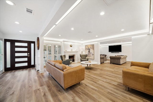 living area featuring a fireplace, recessed lighting, visible vents, light wood-style flooring, and baseboards