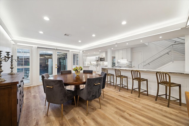 dining room with light wood finished floors, visible vents, and recessed lighting