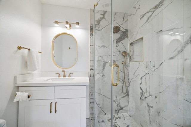 bathroom featuring vanity and a marble finish shower