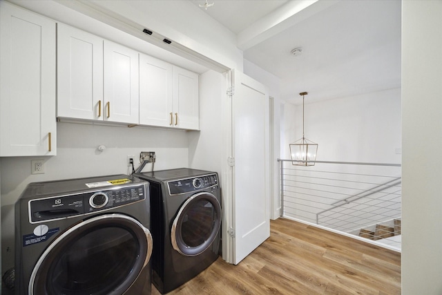 laundry room with light wood-style flooring, a chandelier, cabinet space, and washer and clothes dryer