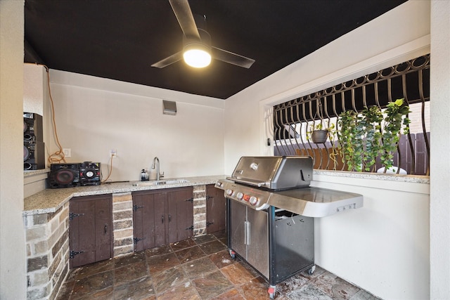 view of patio / terrace featuring a grill, a ceiling fan, an outdoor kitchen, and a sink