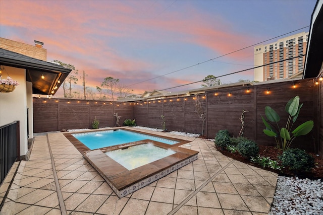 view of swimming pool featuring a fenced backyard, a patio, and an in ground hot tub