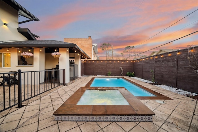 view of swimming pool with a patio area, a fenced backyard, a fenced in pool, and an in ground hot tub