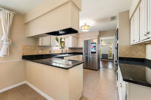 kitchen with a peninsula, a sink, visible vents, smart refrigerator, and dark countertops