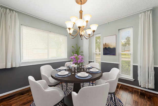 dining space with baseboards, wood-type flooring, a chandelier, and a textured ceiling