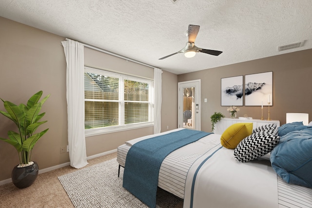 bedroom featuring light carpet, baseboards, visible vents, ceiling fan, and a textured ceiling