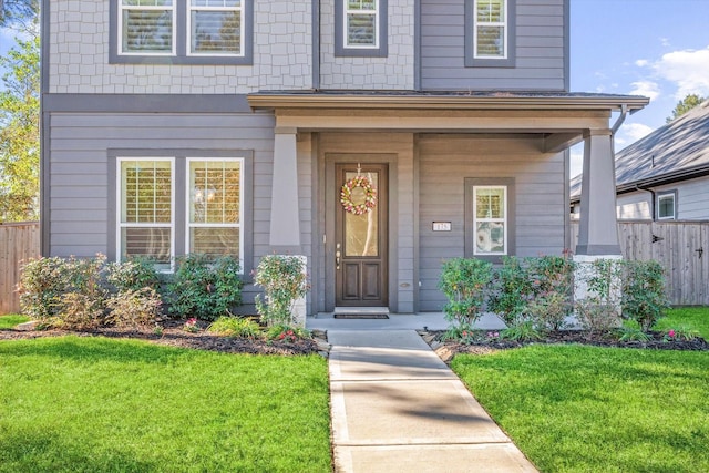 property entrance with a lawn and fence