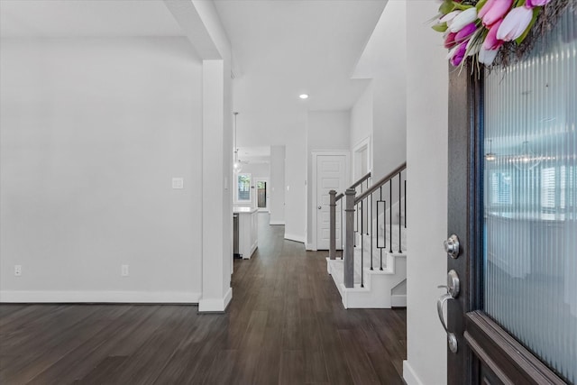 foyer with dark wood-style floors, stairway, and baseboards