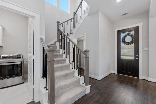 foyer entrance featuring washer / clothes dryer, plenty of natural light, visible vents, and baseboards