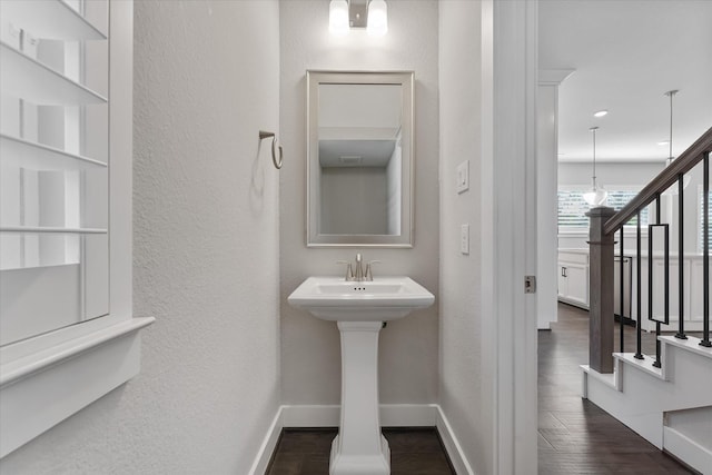 bathroom with a textured wall, wood finished floors, and baseboards