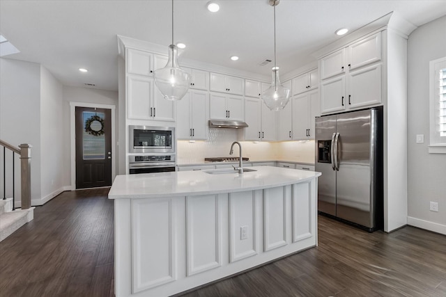 kitchen featuring white cabinets, appliances with stainless steel finishes, hanging light fixtures, light countertops, and under cabinet range hood