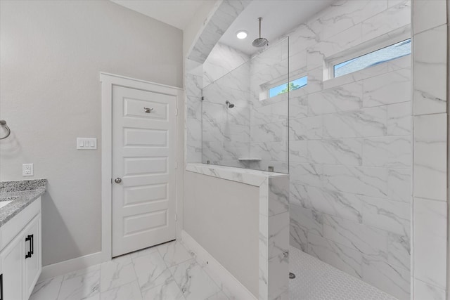 full bathroom featuring marble finish floor, a marble finish shower, vanity, and baseboards