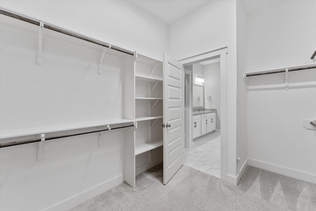 spacious closet with light carpet and marble finish floor