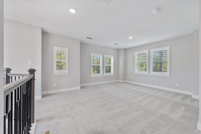 empty room with baseboards, recessed lighting, and light colored carpet