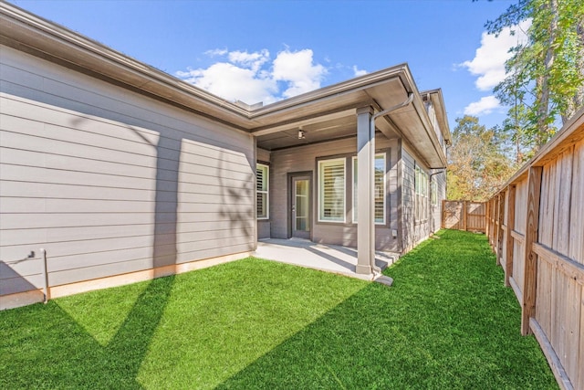 rear view of house with a patio area, a fenced backyard, and a lawn