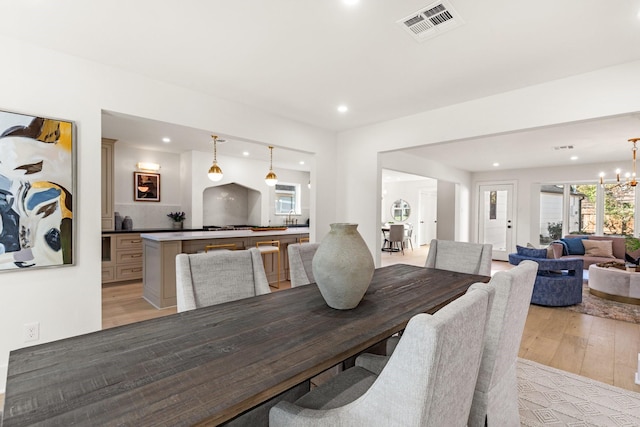 dining area with light wood finished floors, visible vents, a chandelier, and recessed lighting