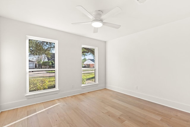 empty room with baseboards, ceiling fan, and light wood-style floors