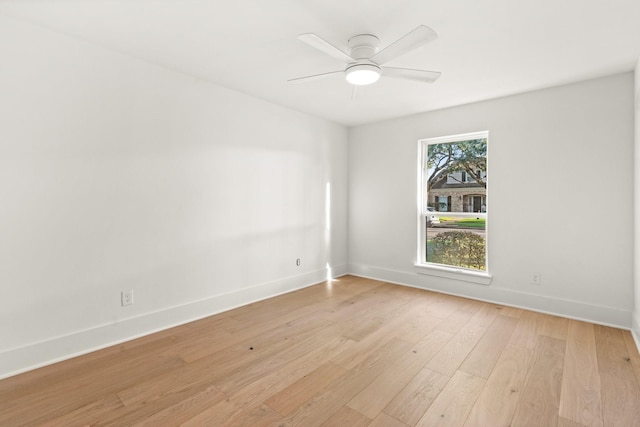 empty room with a ceiling fan, light wood-style flooring, and baseboards