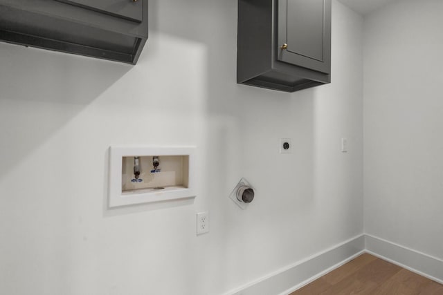 washroom featuring hookup for a washing machine, dark wood-type flooring, baseboards, cabinet space, and electric dryer hookup