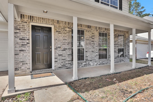 property entrance with covered porch and brick siding