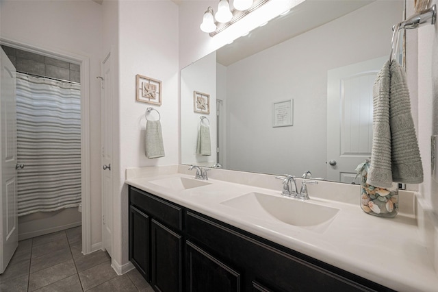 full bathroom featuring double vanity, a sink, baseboards, and tile patterned floors