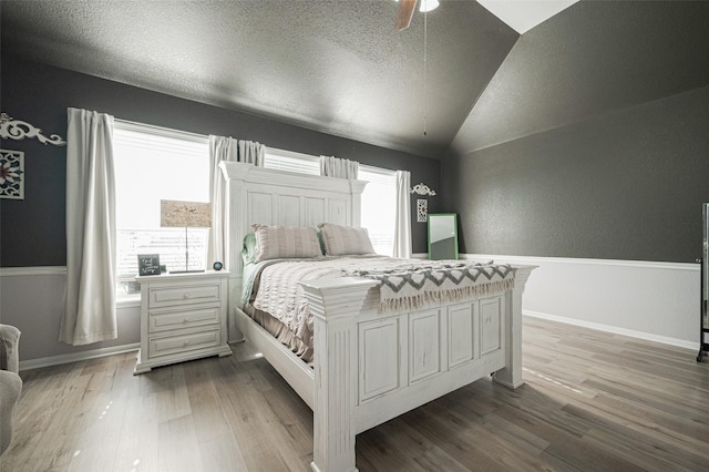 bedroom featuring lofted ceiling, light wood-type flooring, and multiple windows