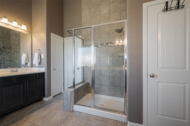 bathroom featuring baseboards, a shower stall, vanity, and tile patterned floors